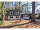 Charming home featuring a split-level design, gray and white exterior, blue shutters, and a well-maintained front yard at 8744 Bellwood Ct, Riverdale, GA 30274