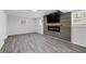 Open living room featuring wood-look flooring and modern electric fireplace with wall-mounted television at 8744 Bellwood Ct, Riverdale, GA 30274