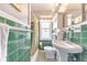 Green and white bathroom featuring a shower with curtain, toilet, and a pedestal sink at 1446 Lively Ridge Ne Rd, Atlanta, GA 30329