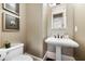 Neutral colored powder room featuring a pedestal sink and framed art that enhances the home's aesthetic appeal at 3633 Broughton Se Cir, Atlanta, GA 30339