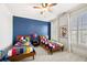 A colorful bedroom includes two beds with a ceiling fan, a navy accent wall, and a large window at 3633 Broughton Se Cir, Atlanta, GA 30339