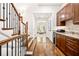 Hallway with hardwood floors, staircase, and butler's pantry area with custom cabinets and granite countertop at 3633 Broughton Se Cir, Atlanta, GA 30339