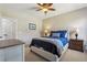 This bedroom features neutral walls, carpet, a ceiling fan, a large window, and a comfortable bed with blue linens at 4375 Maverick Nw Ln, Kennesaw, GA 30152