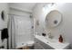 Bright bathroom with a shower-tub, vanity with a round mirror and black and white decor at 1637 Duncan Nw Dr, Atlanta, GA 30318