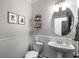 Charming powder room features a pedestal sink, round mirror, and decorative wall accents at 1637 Duncan Nw Dr, Atlanta, GA 30318