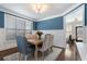 Elegant dining room featuring blue accent walls, wainscoting, and a modern chandelier, perfect for Gathering meals at 1637 Duncan Nw Dr, Atlanta, GA 30318