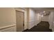 Condo hallway with a carpeted floor, stylish paneling, and the door to unit 222 at 222 Ashford Cir # 222, Atlanta, GA 30338