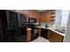 A well lit kitchen featuring wooden cabinets and modern appliances, including a black refrigerator at 222 Ashford Cir # 222, Atlanta, GA 30338