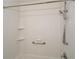 All-white bathroom with grab bar, handheld shower head, and built-in shelves at 2971 Ruby Ct, Powder Springs, GA 30127