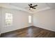 Spacious bedroom with a tray ceiling, two windows providing natural light, and modern ceiling fan at 2971 Ruby Ct, Powder Springs, GA 30127