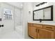 Modern bathroom with a marble tiled shower, quartz countertop, and wood cabinets at 3182 Glynn Mill Dr, Snellville, GA 30039