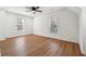 Bright bedroom featuring hardwood floors, two large windows, and a modern ceiling fan at 3182 Glynn Mill Dr, Snellville, GA 30039