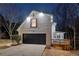 Charming home exterior at night featuring a garage, deck, and manicured landscaping at 3182 Glynn Mill Dr, Snellville, GA 30039