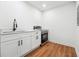 Modern kitchenette featuring white cabinets, quartz countertops, a stainless steel oven, and wood-look floors at 3182 Glynn Mill Dr, Snellville, GA 30039