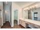 Bathroom featuring a large mirror, double sink vanity and a closet entrance at 9185 Brockham Way, Alpharetta, GA 30022