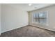 This bedroom has neutral walls, carpet and a bright window at 9185 Brockham Way, Alpharetta, GA 30022