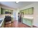 Spacious kitchen featuring bright green cabinets, stainless appliances and wood floors at 9185 Brockham Way, Alpharetta, GA 30022