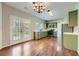 Bright kitchen features stainless steel appliances, green cabinets, and wood floors and French doors at 9185 Brockham Way, Alpharetta, GA 30022