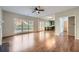 Open-concept room features hardwood floors, large windows, fireplace, and a view into the kitchen at 9185 Brockham Way, Alpharetta, GA 30022