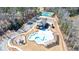 Aerial view showcasing community pool, tennis courts, clubhouse and surrounding wooded area at 17 Baral Rdg, Sharpsburg, GA 30277