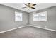 A cozy bedroom featuring neutral gray walls and carpet with a ceiling fan and two windows at 2006 Conrad Se Ave, Atlanta, GA 30315