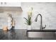 Close-up of kitchen sink area featuring granite counters and marble backsplash at 1073 Oakland Drive Sw Dr, Atlanta, GA 30310