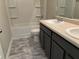 Bathroom featuring double sink vanity and tub with shower at 11978 Lovejoy Crossing Way, Hampton, GA 30228