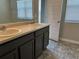 Bathroom featuring dual sinks with grey cabinetry and modern fixtures at 11978 Lovejoy Crossing Way, Hampton, GA 30228