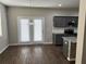 Dining area features wood floors, gray cabinets, granite countertops, and French doors leading to the backyard at 11978 Lovejoy Crossing Way, Hampton, GA 30228