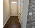 Inviting hallway with wood floors, a decorative stone accent wall, coat closet, and a bright front door at 11978 Lovejoy Crossing Way, Hampton, GA 30228