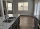 Bright kitchen with granite countertops, gray cabinets, and view to dining area and fireplace at 11978 Lovejoy Crossing Way, Hampton, GA 30228