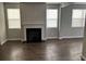 Cozy living room features a fireplace, large windows, and hardwood floors, creating an inviting atmosphere at 11978 Lovejoy Crossing Way, Hampton, GA 30228