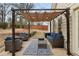 Relaxing backyard patio area under a pergola, complete with comfortable seating and ambient lighting at 172 Sweet Branch Ct, Grayson, GA 30017