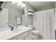 Bright bathroom featuring a white vanity, large mirror, and shower behind a white curtain at 172 Sweet Branch Ct, Grayson, GA 30017