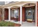 Inviting front porch with rocking chairs and gray front door, enhanced by brick detailing and white support columns at 172 Sweet Branch Ct, Grayson, GA 30017