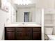 Bathroom showcasing a dark wood vanity, a spacious countertop, and a large mirror at 6356 Kennonbriar Ct, Lithonia, GA 30058