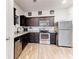 Modern kitchen featuring stainless steel appliances, dark cabinetry, and granite countertops at 6356 Kennonbriar Ct, Lithonia, GA 30058