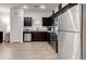 Well-lit kitchen boasts stainless steel appliances and dark cabinets at 6356 Kennonbriar Ct, Lithonia, GA 30058