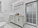 Well-lit bathroom features dual sinks on a vanity with marble countertop at 1564 Bubbling Creek Rd, Brookhaven, GA 30319