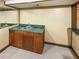 Basement wet bar featuring wood cabinets, green countertop, sink and carpet at 1831 Killarney Sw Dr, Marietta, GA 30008