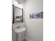 This bathroom features a pedestal sink with a mounted mirror and mountain-themed wall art at 3037 Ferrington Way, Smyrna, GA 30080