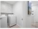 Bright laundry room featuring a modern washer and dryer with a decorative, gray brick accent wall at 3037 Ferrington Way, Smyrna, GA 30080