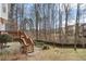 Backyard featuring a brick patio, deck, wooden staircase, grass, and mature trees at 3510 Estates Landing Nw Dr, Kennesaw, GA 30144