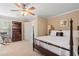 Bedroom with neutral walls, fan, rocker, bookshelf, and large bed at 3510 Estates Landing Nw Dr, Kennesaw, GA 30144