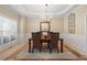 Traditional dining room with a modern chandelier, wainscoting, and views of the front yard at 3510 Estates Landing Nw Dr, Kennesaw, GA 30144