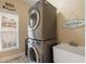 Small laundry room features stacked front-load washer and dryer with utility sink at 3510 Estates Landing Nw Dr, Kennesaw, GA 30144