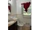 Cozy bathroom with sink, toilet, window with red curtain, and white tiled walls at 4188 Fontana Ct, Tucker, GA 30084