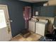 A laundry room featuring tile floors, blue walls, cabinets, and a door to the outside at 4188 Fontana Ct, Tucker, GA 30084