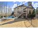 Lush backyard featuring a stone-edged pool, spacious yard, elevated deck, and black fence for secure outdoor enjoyment at 5245 Wilshire Xing, Cumming, GA 30040