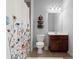 Guest bathroom featuring shower with floral shower curtain, vanity with sink and tile flooring at 5245 Wilshire Xing, Cumming, GA 30040